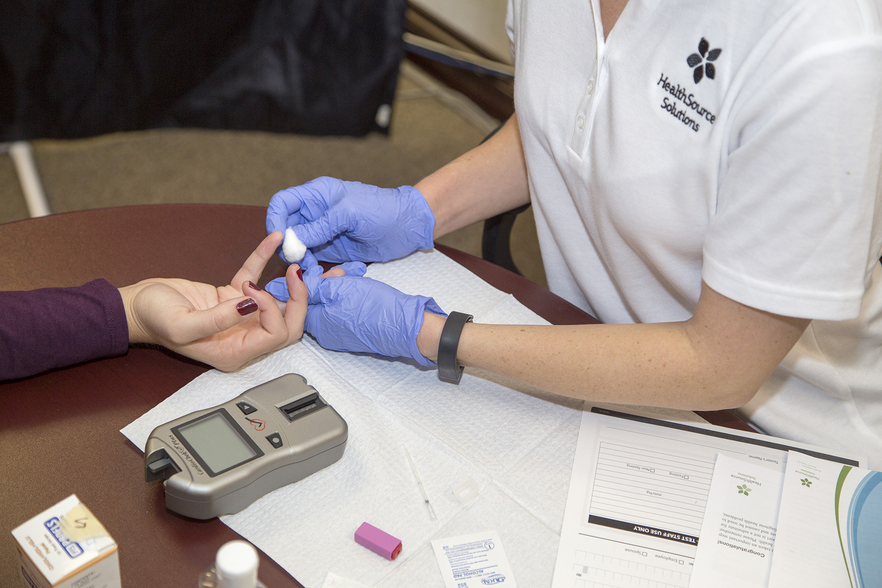 Nurses hands taking blood from a patient for a biometric screening