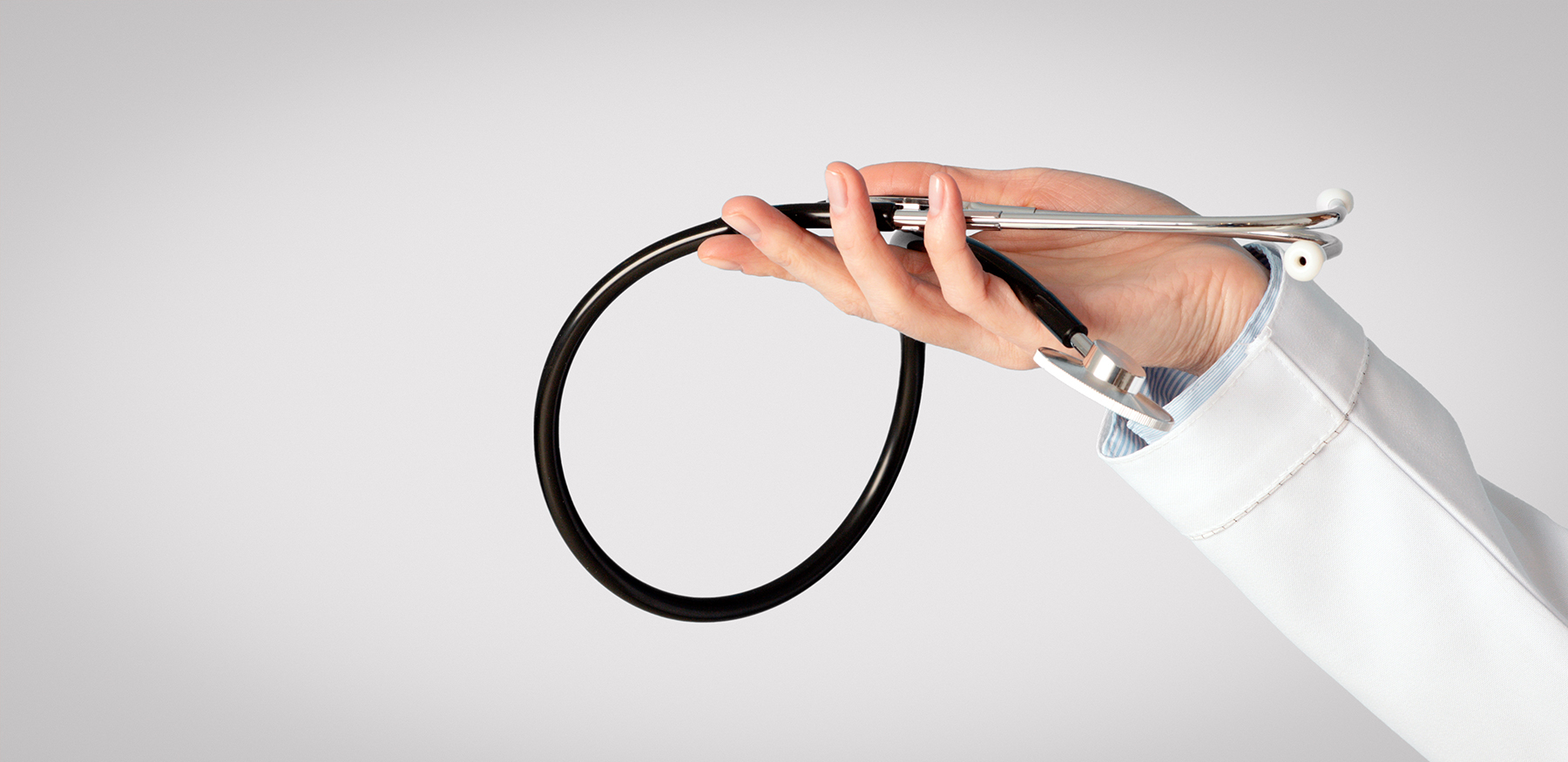 Medical examination, diagnostics and health protection. Doctor woman in white coat holds stethoscope in hand hand holding stethoscope