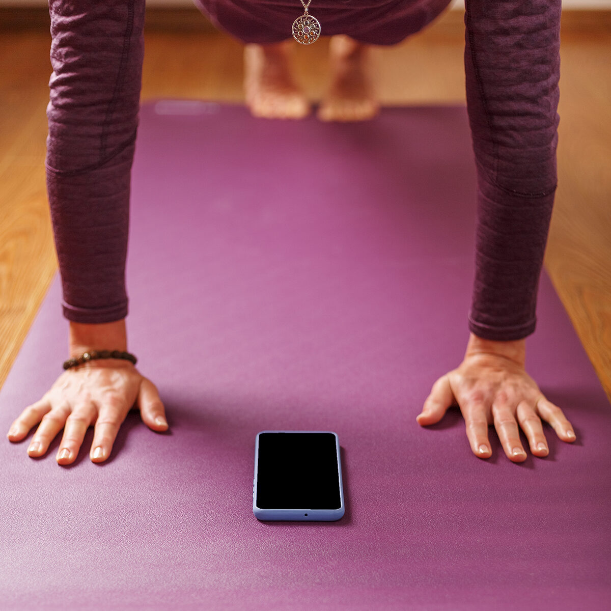 Yoga online training workout by smartphone, using the fitness app at home in the gym. Online yoga and meditation practices. Place on the smartphone screen