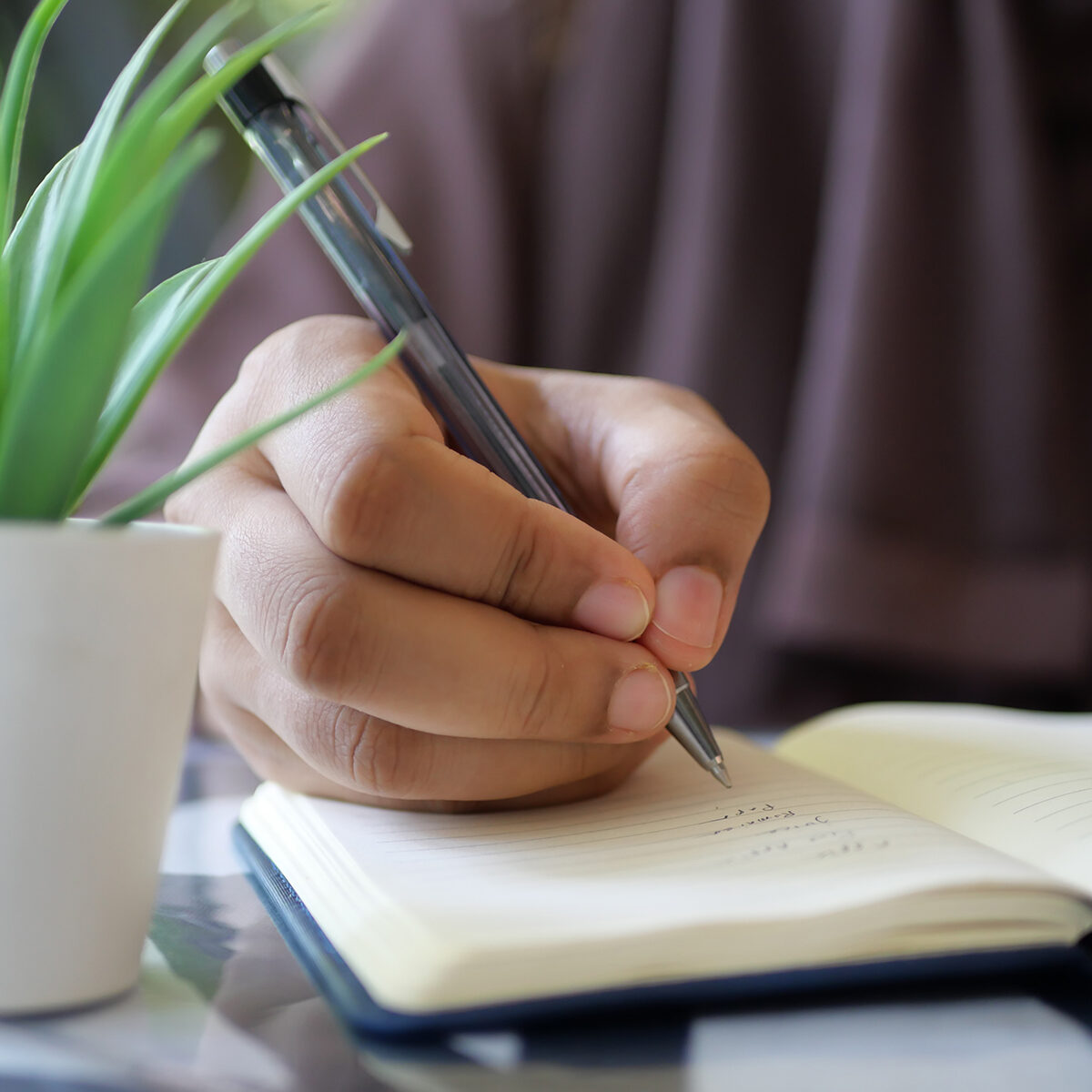 Close up of women hand writing on notepad