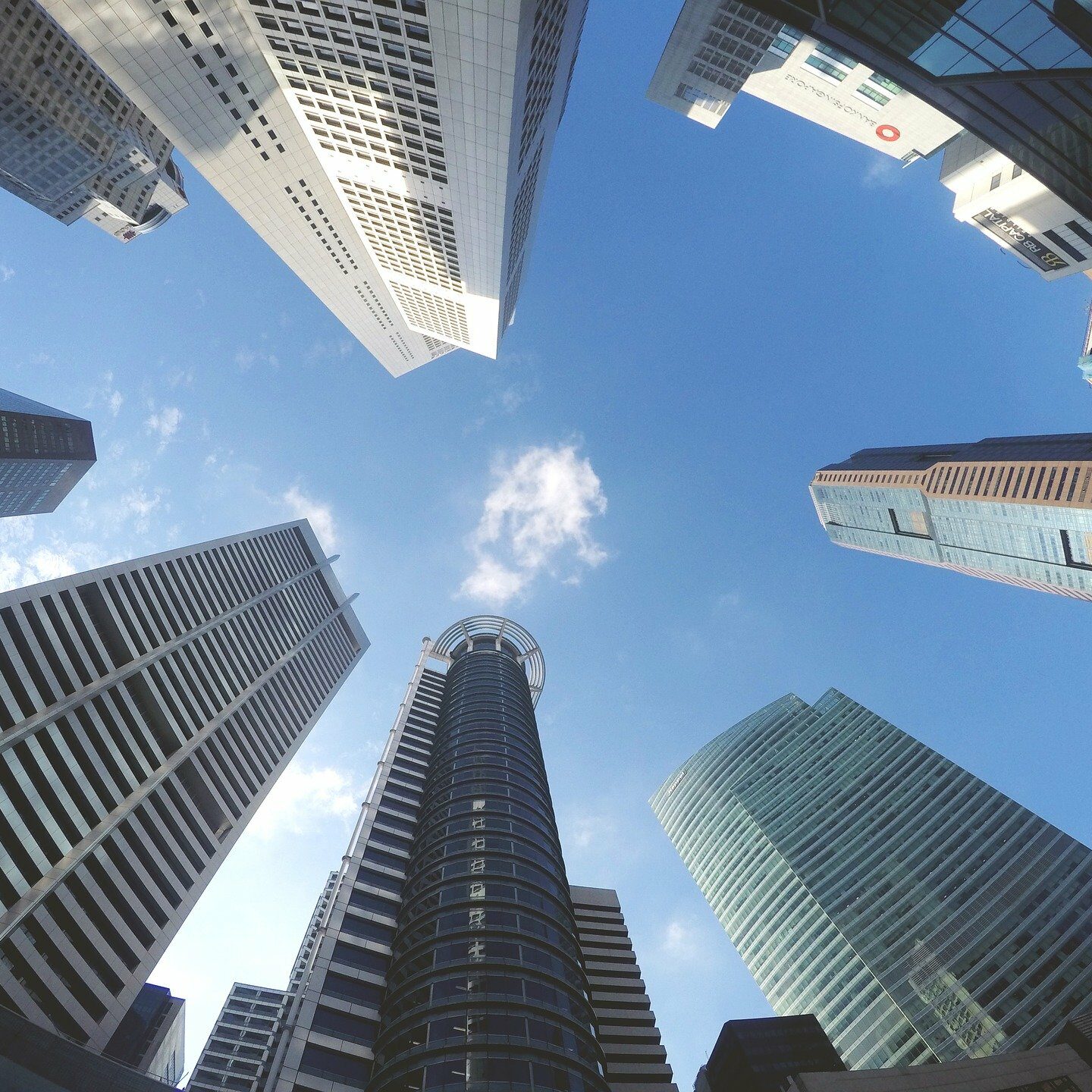 fish eye lens looking up at skyscrapers to blue sky
