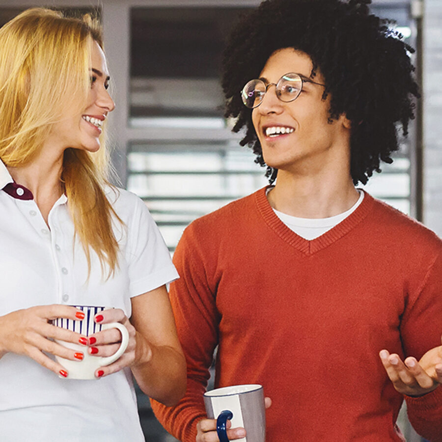 Friendly colleagues enjoying coffee in modern office