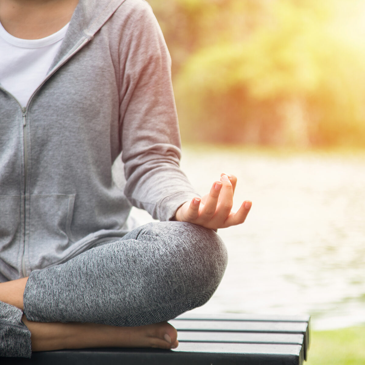 Young yoga woman meditation on the ocean beach at amazing sunset. Woman Yoga - relax in nature.